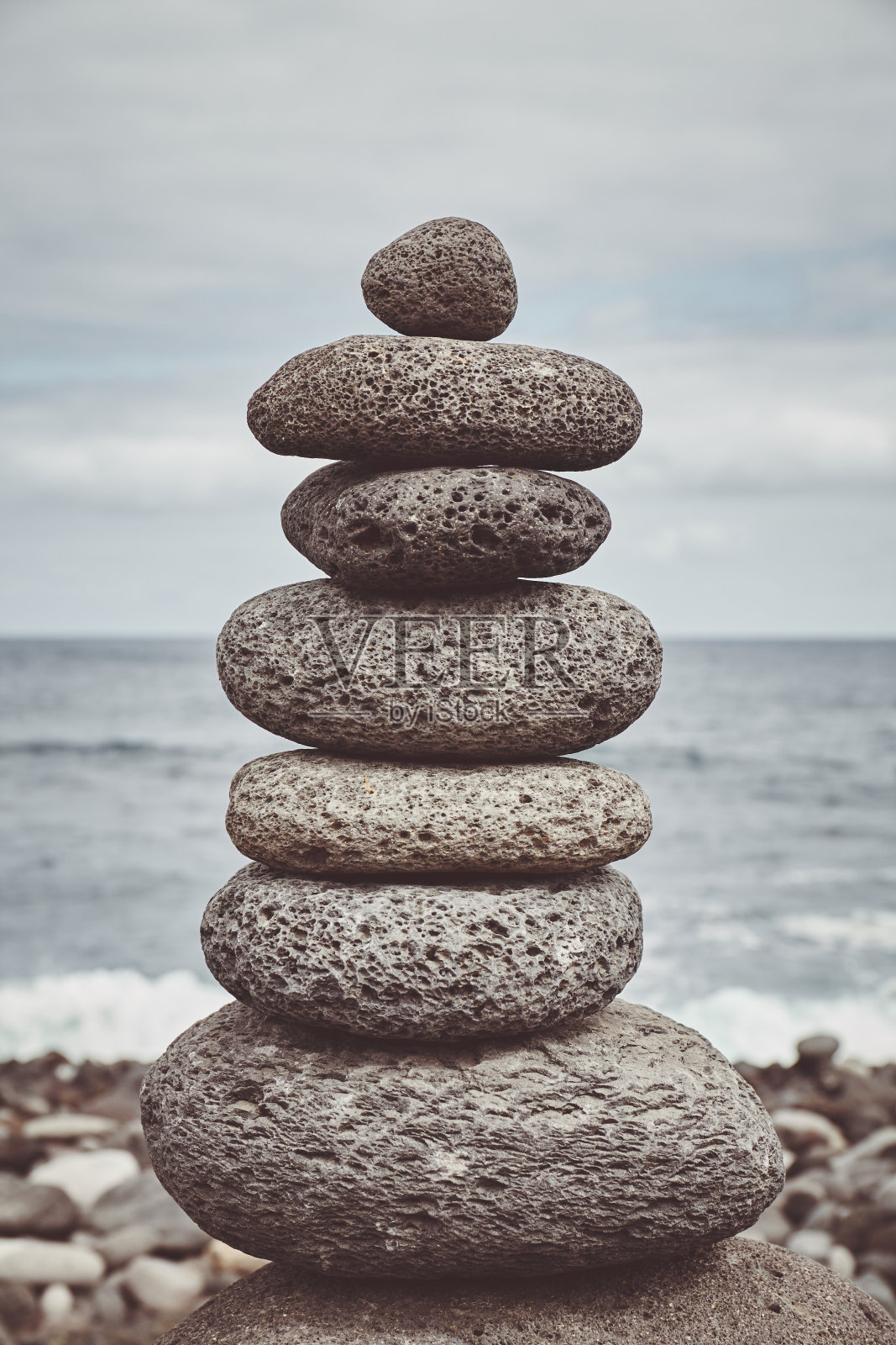 在海滩上的一个石头堆栈的彩色色调的图片。照片摄影图片