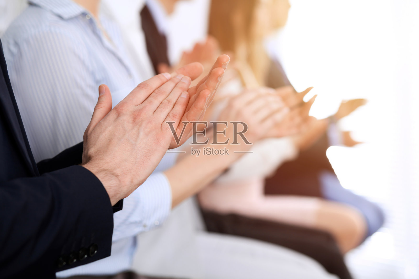 商务人士在会议或会议上拍手、鼓掌、举手。一群不知名的商人和妇女在现代白人办公室。成功的团队合作或企业培训理念照片摄影图片