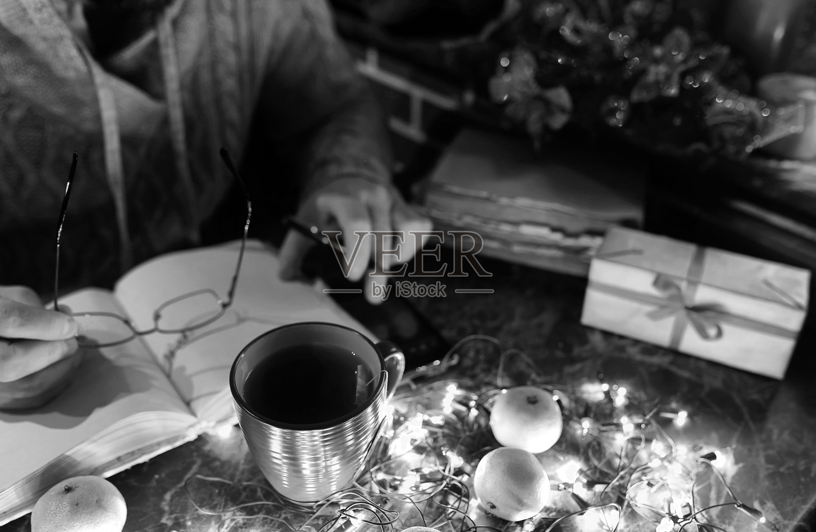 一个男人手里拿着一本空白的书的黑白照片,用于装饰新年的桌子照片摄影图片