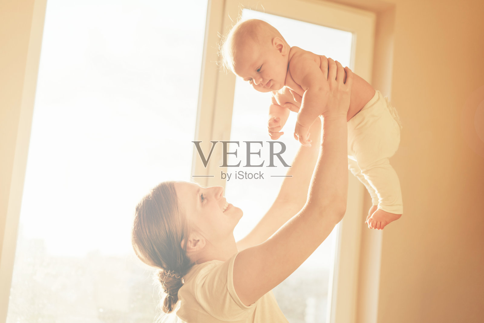 妈妈用手把婴儿举过头顶照片摄影图片