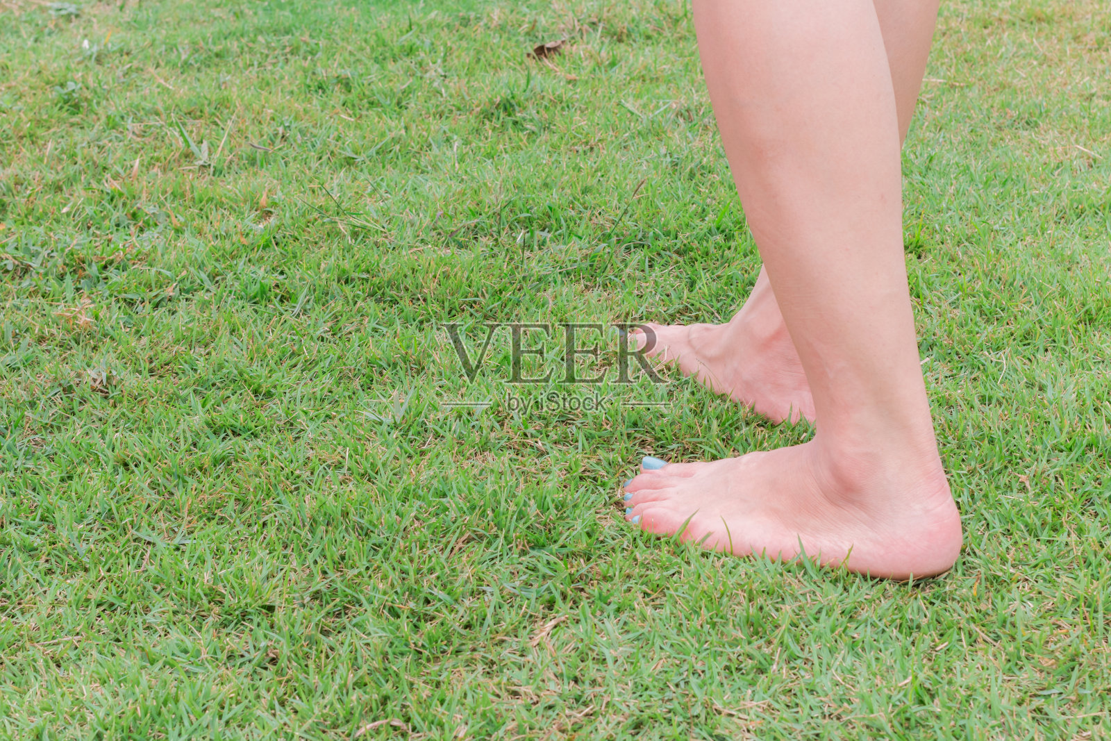 脚光着脚踩在绿草地上照片摄影图片