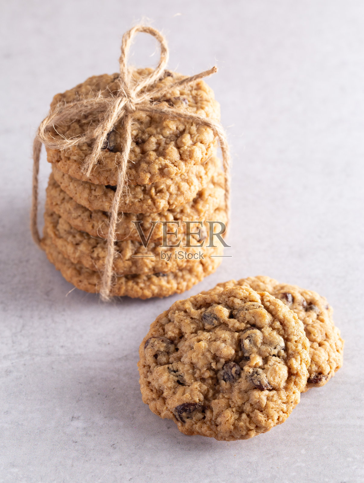 灰色石板桌上的肉桂葡萄干燕麦饼干照片摄影图片