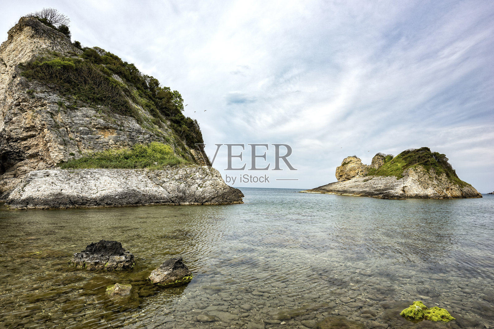 日落时的岩石海岸。美丽的自然和戏剧性的天空。照片摄影图片