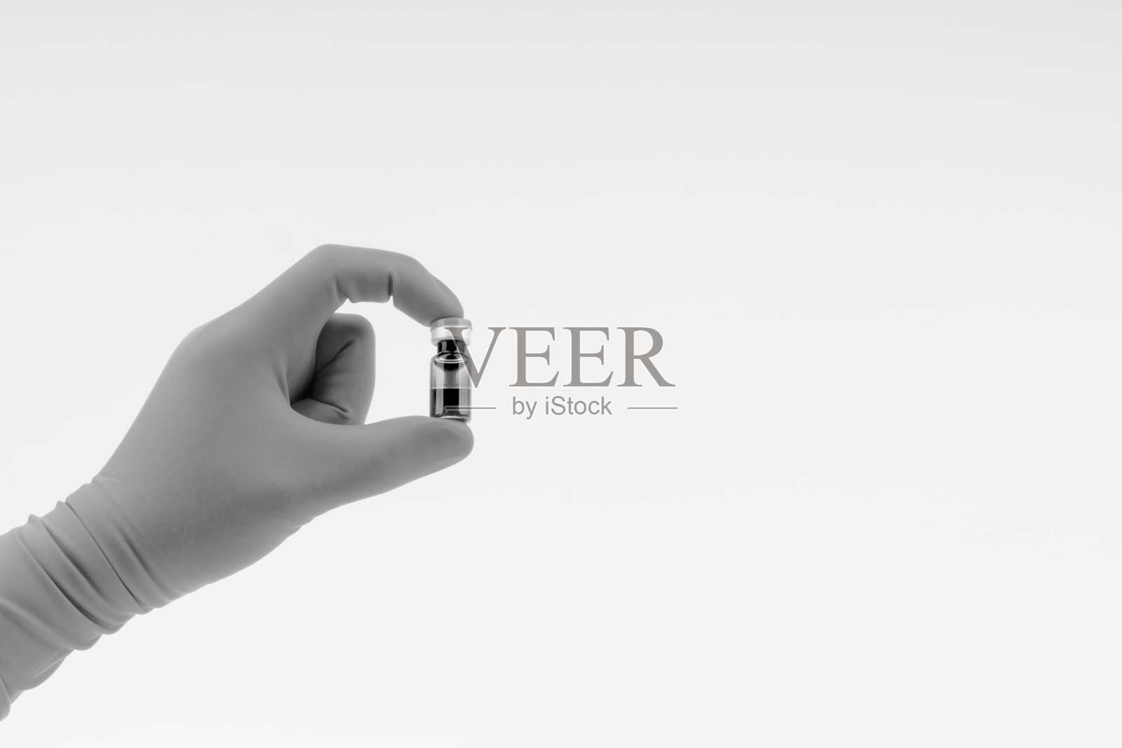 在黑色和白色的手上有一个蓝色的手套拿着药瓶照片摄影图片