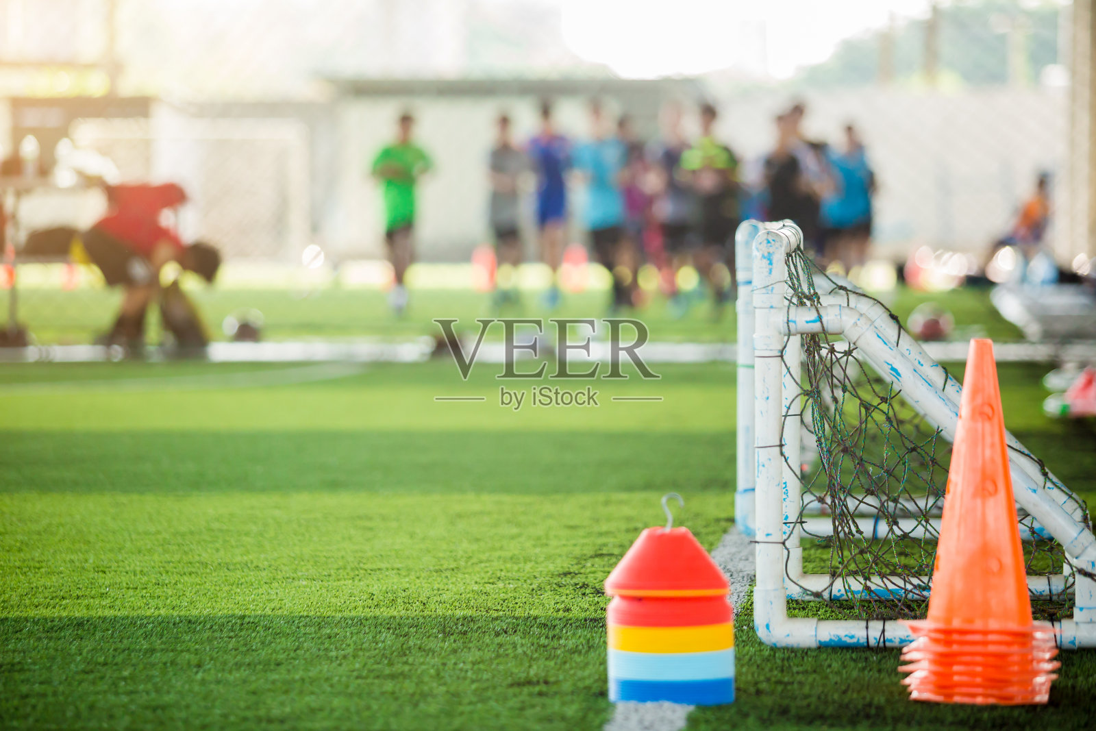 足球训练用绿色人造草皮上的多色标记锥和小球门照片摄影图片