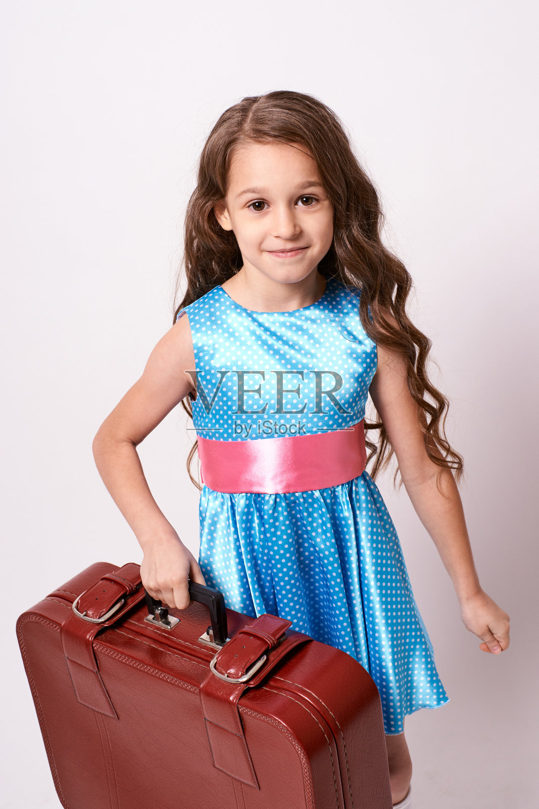 等待旅行。可爱的小女孩。大的行李箱照片摄影图片