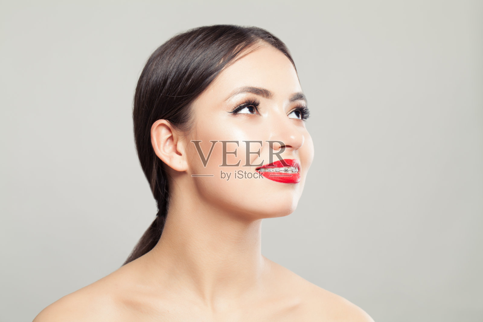 可爱的女人在牙套微笑的白色照片摄影图片