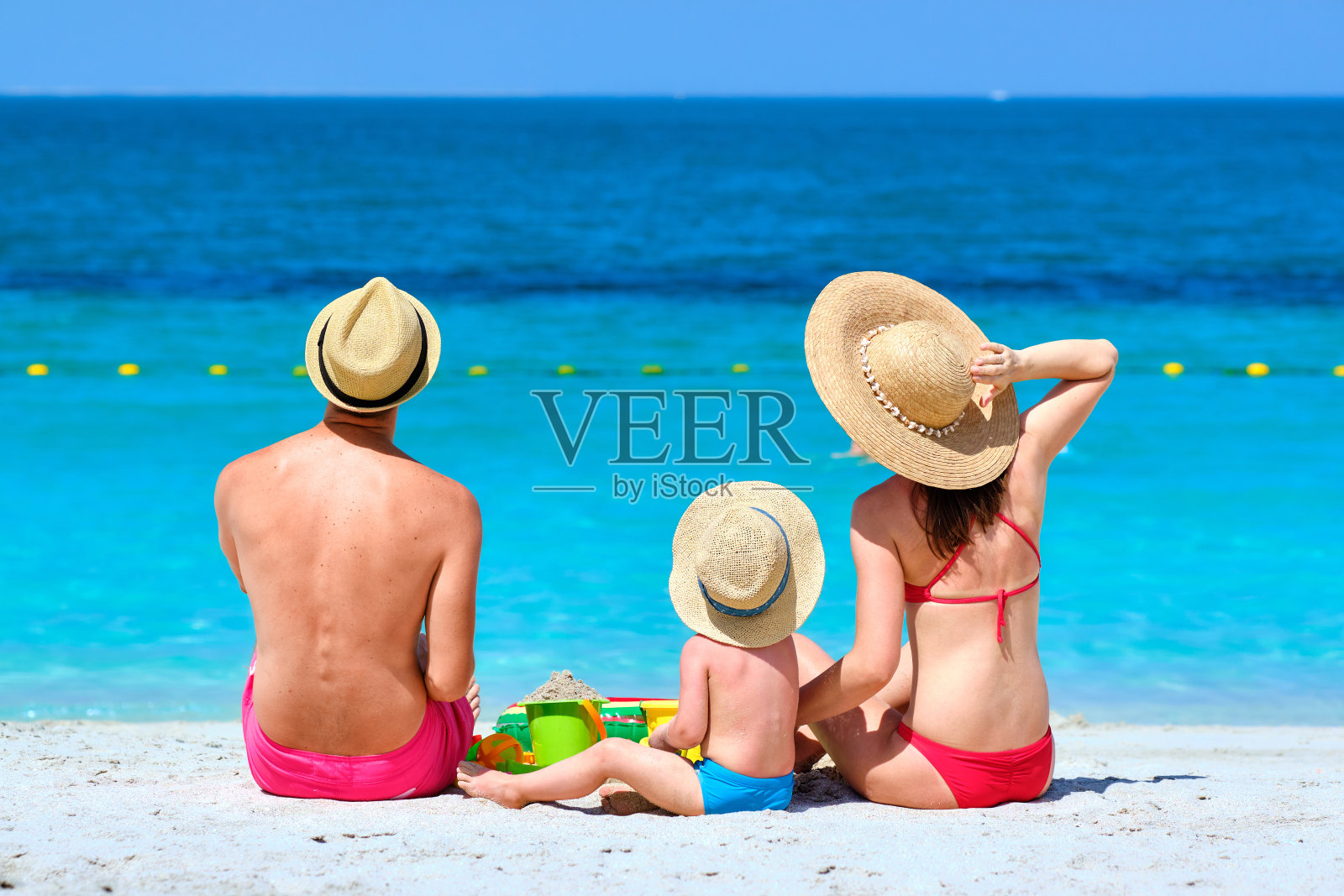 海滩上的家庭:幼儿与父母玩耍照片摄影图片