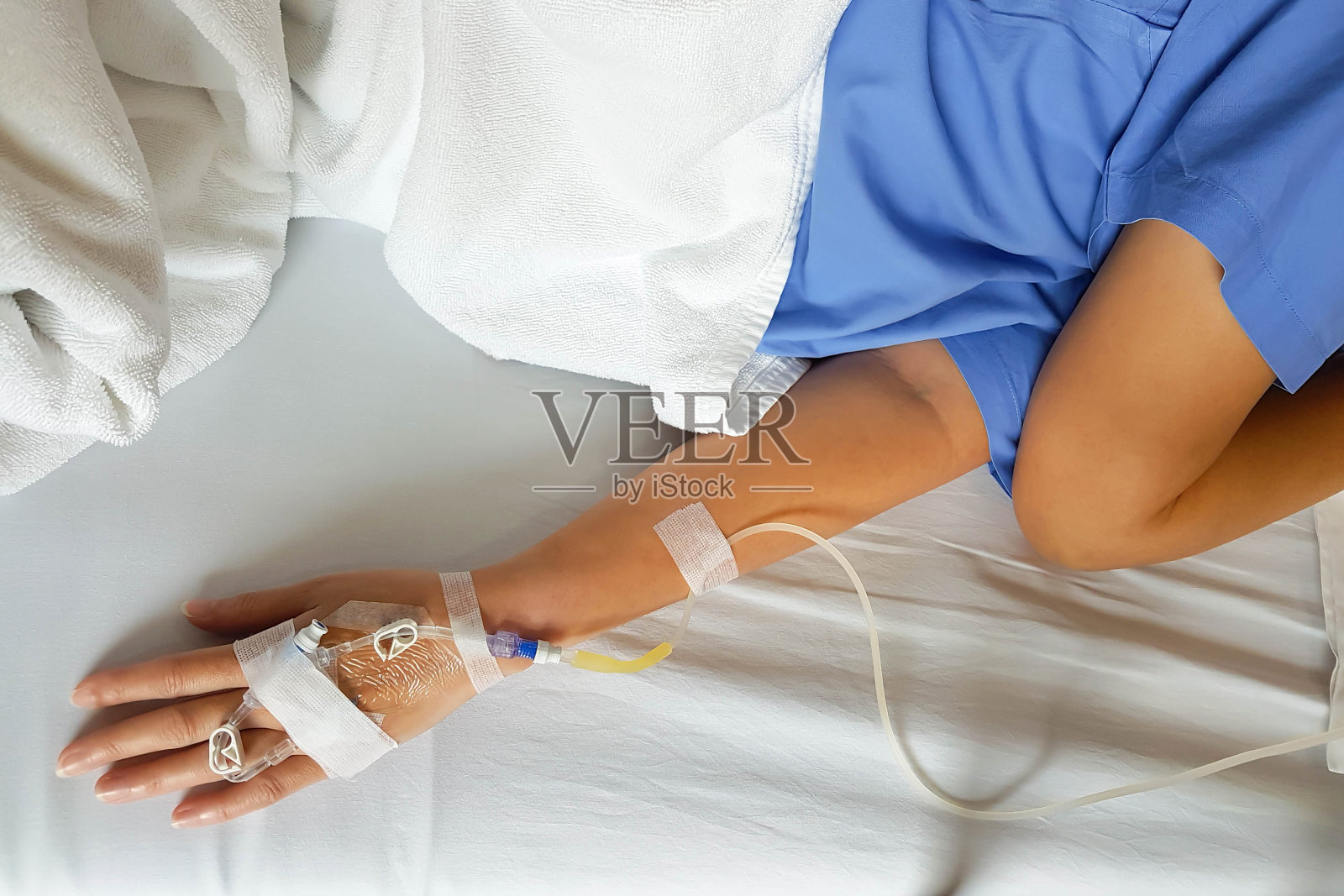 使用滴注针静脉输液病人的手。照片摄影图片