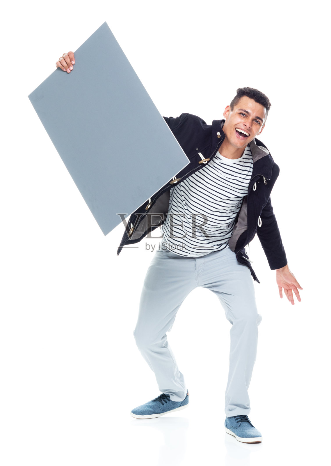 英俊的黑人穿着夹克和灰色裤子-举着一个有趣的方式照片摄影图片