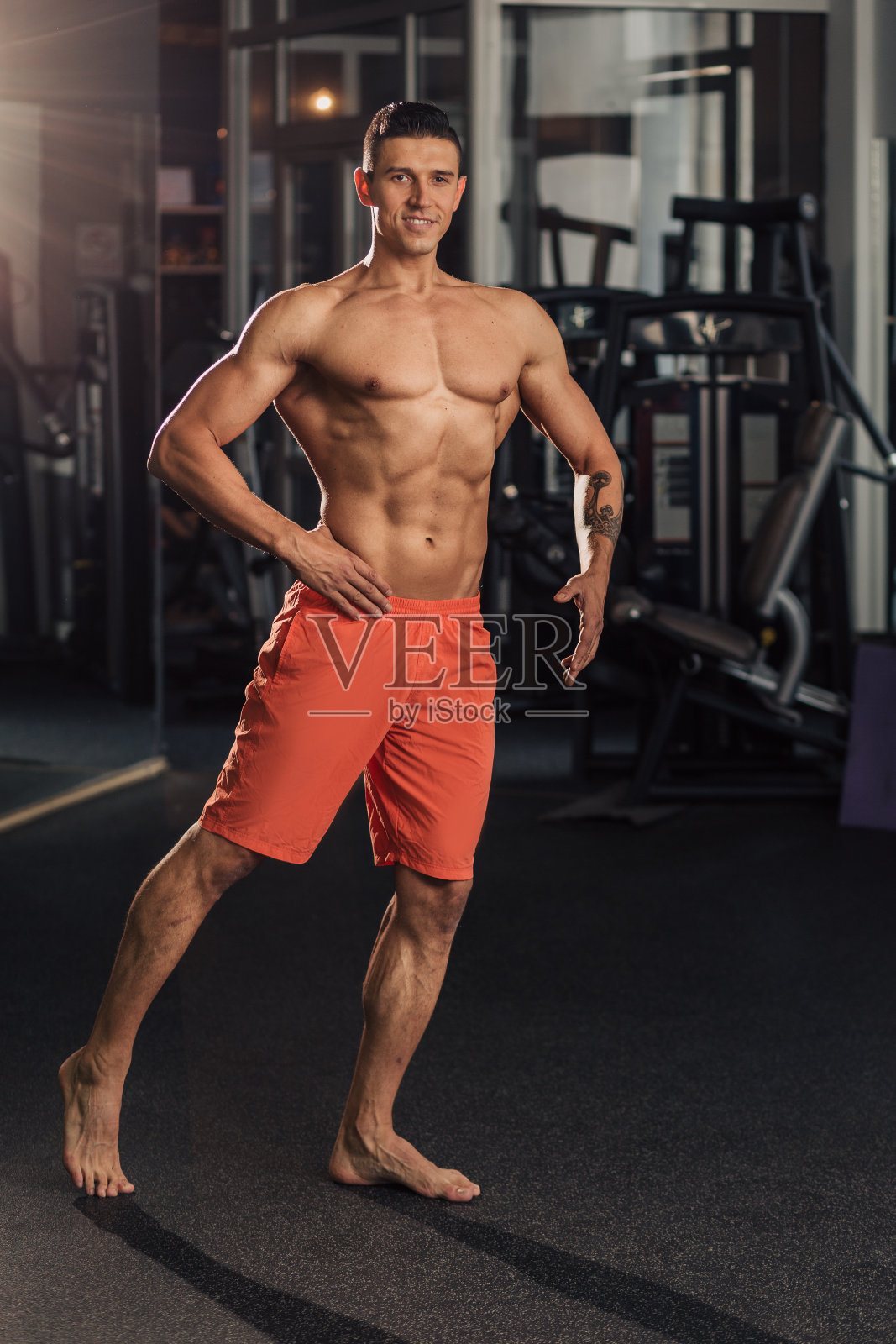 年轻的肌肉男在体育馆做运动照片摄影图片