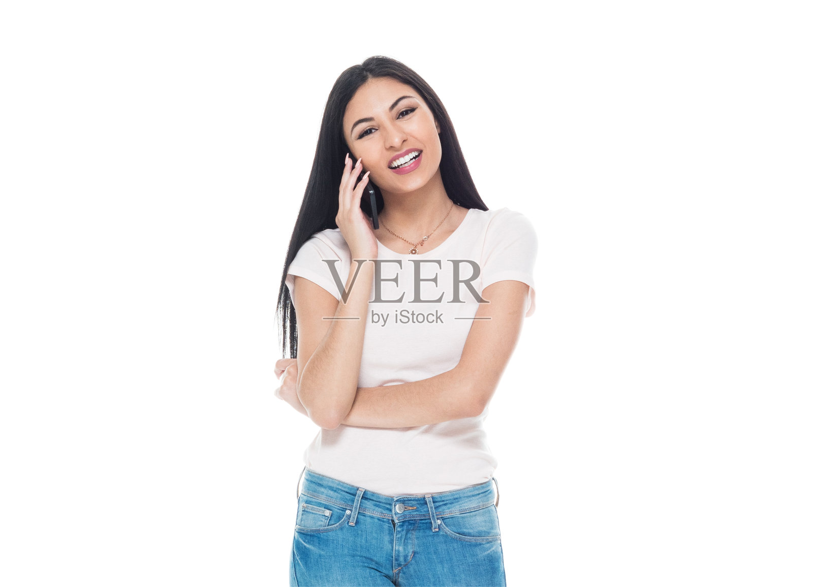 美丽年轻的拉丁裔女性穿着t恤和牛仔裤-谈论智能手机照片摄影图片