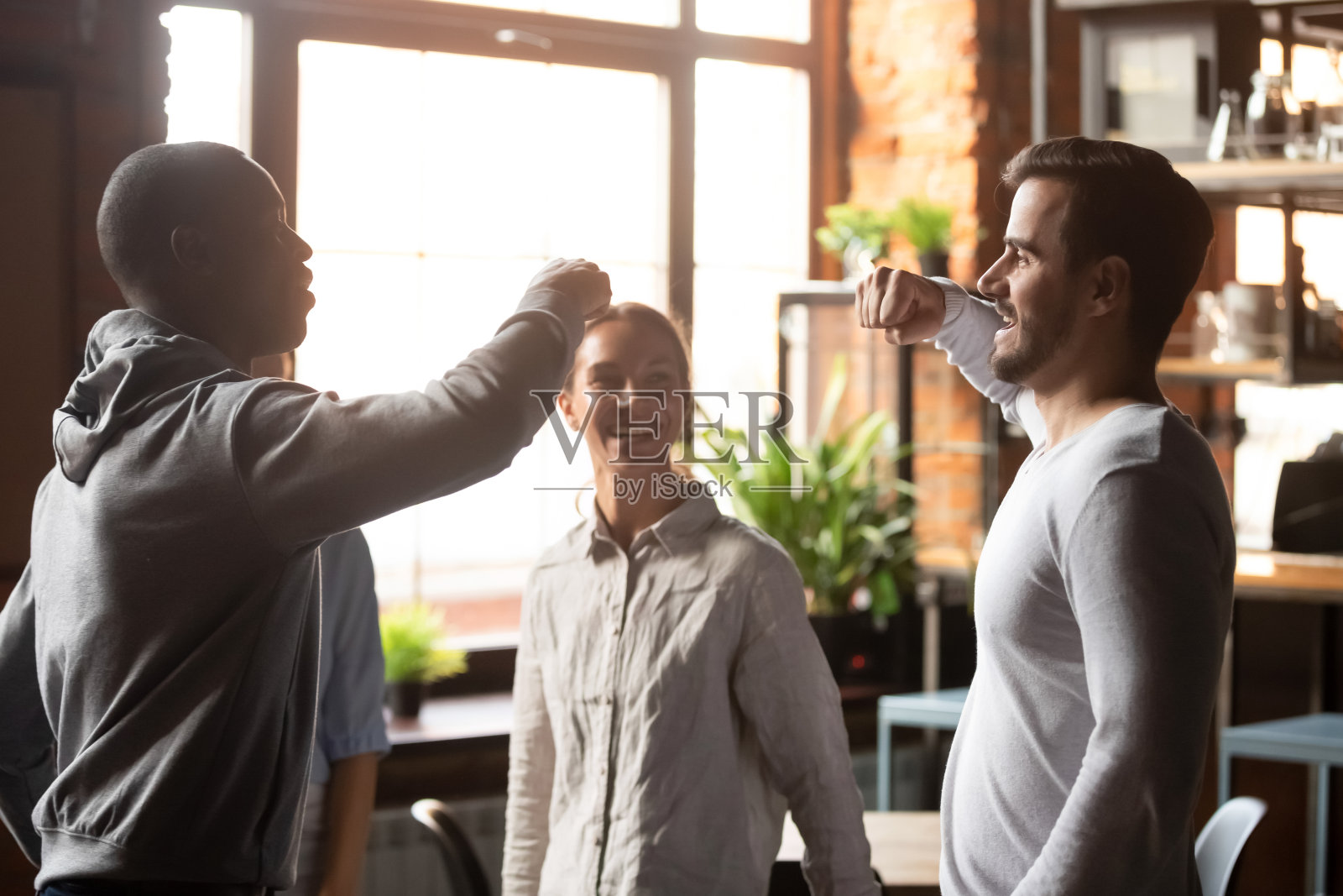 非裔美国人和白人男子在咖啡馆见面时互击拳头照片摄影图片