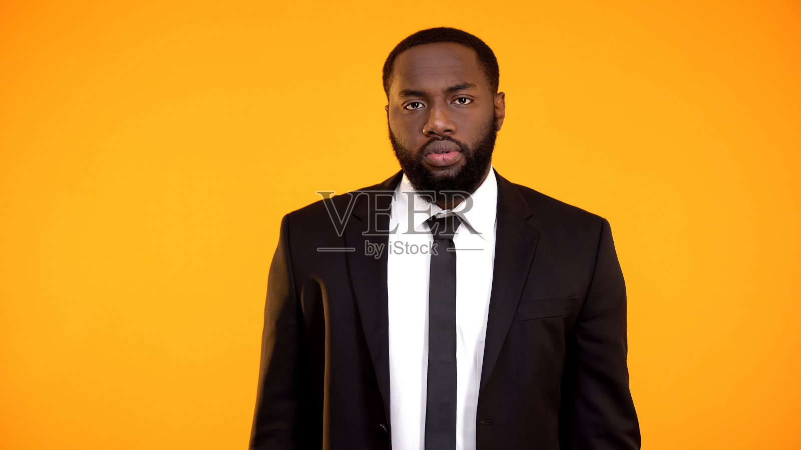 失望的非裔美国商人看着相机,质量很差照片摄影图片