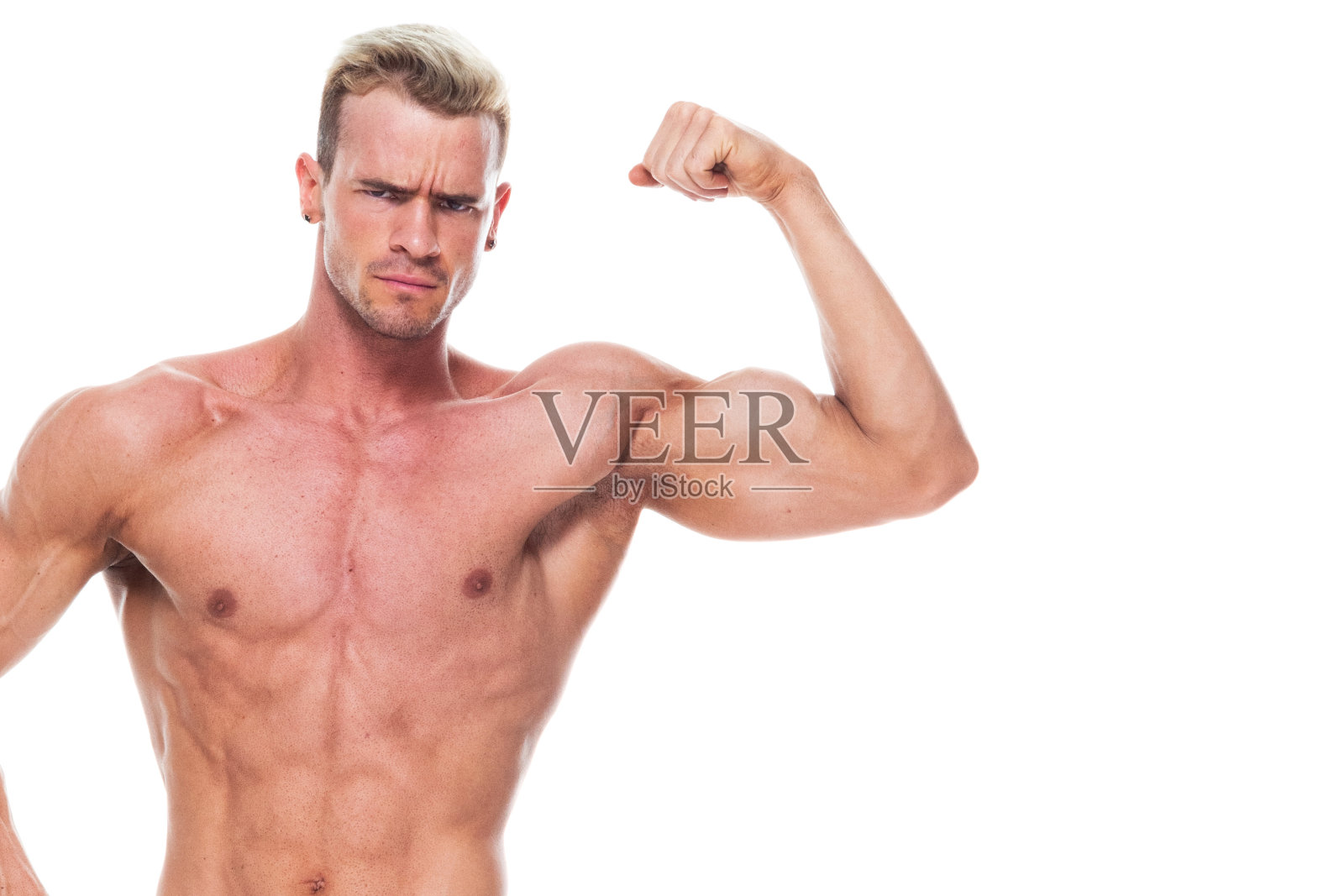 英俊的肌肉男子谁是赤膊和穿着板短裤和弯曲他的肌肉照片摄影图片