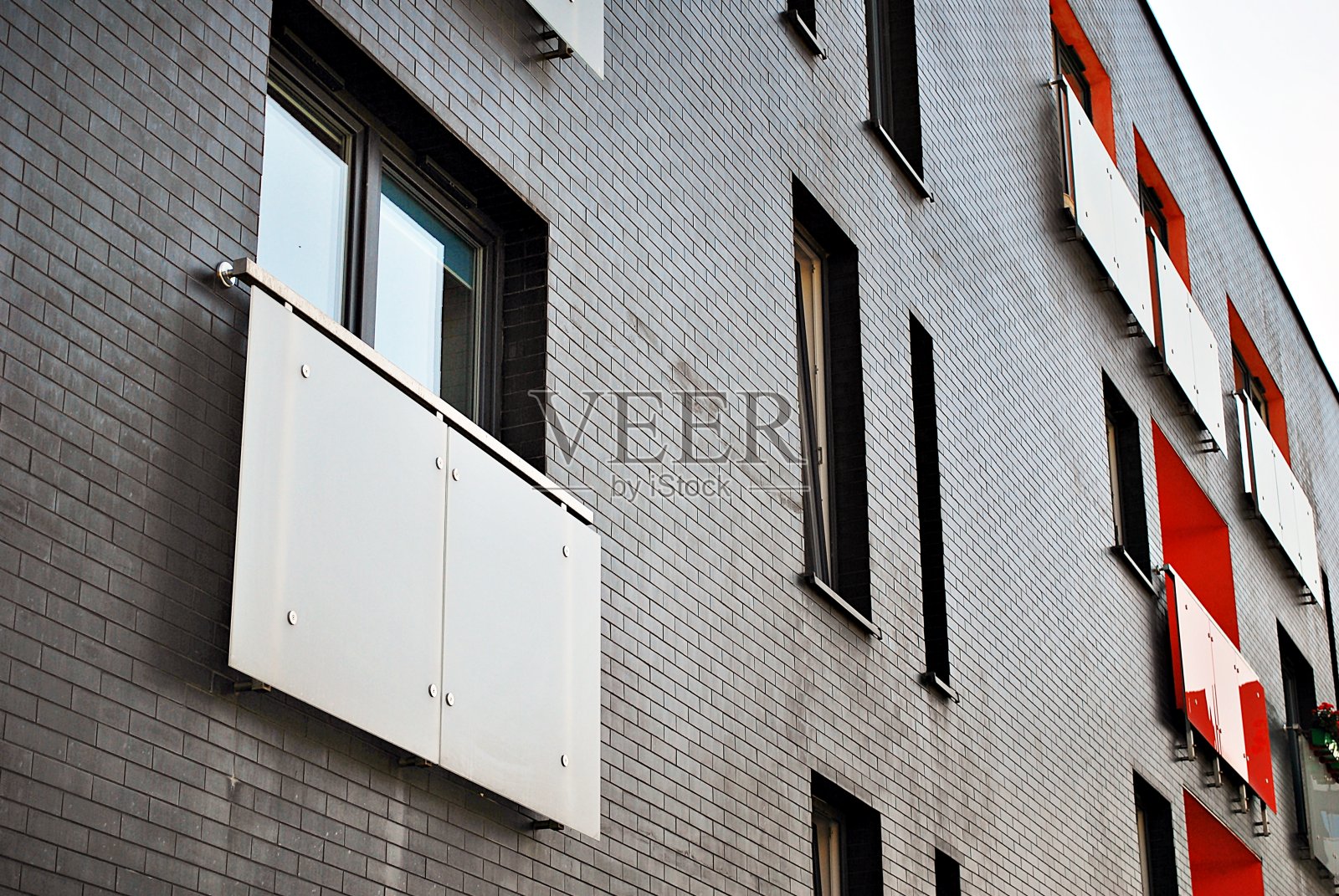 现代化的公寓大楼在一个晴朗的日子与蓝天。现代公寓楼的立面照片摄影图片