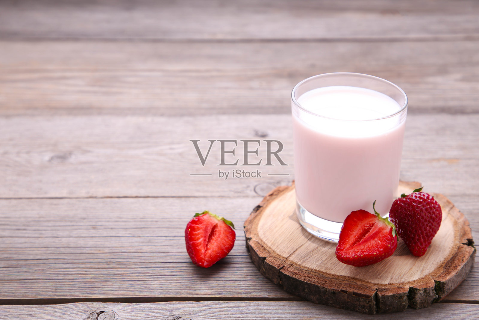 酸奶与草莓玻璃在灰色的木制背景照片摄影图片