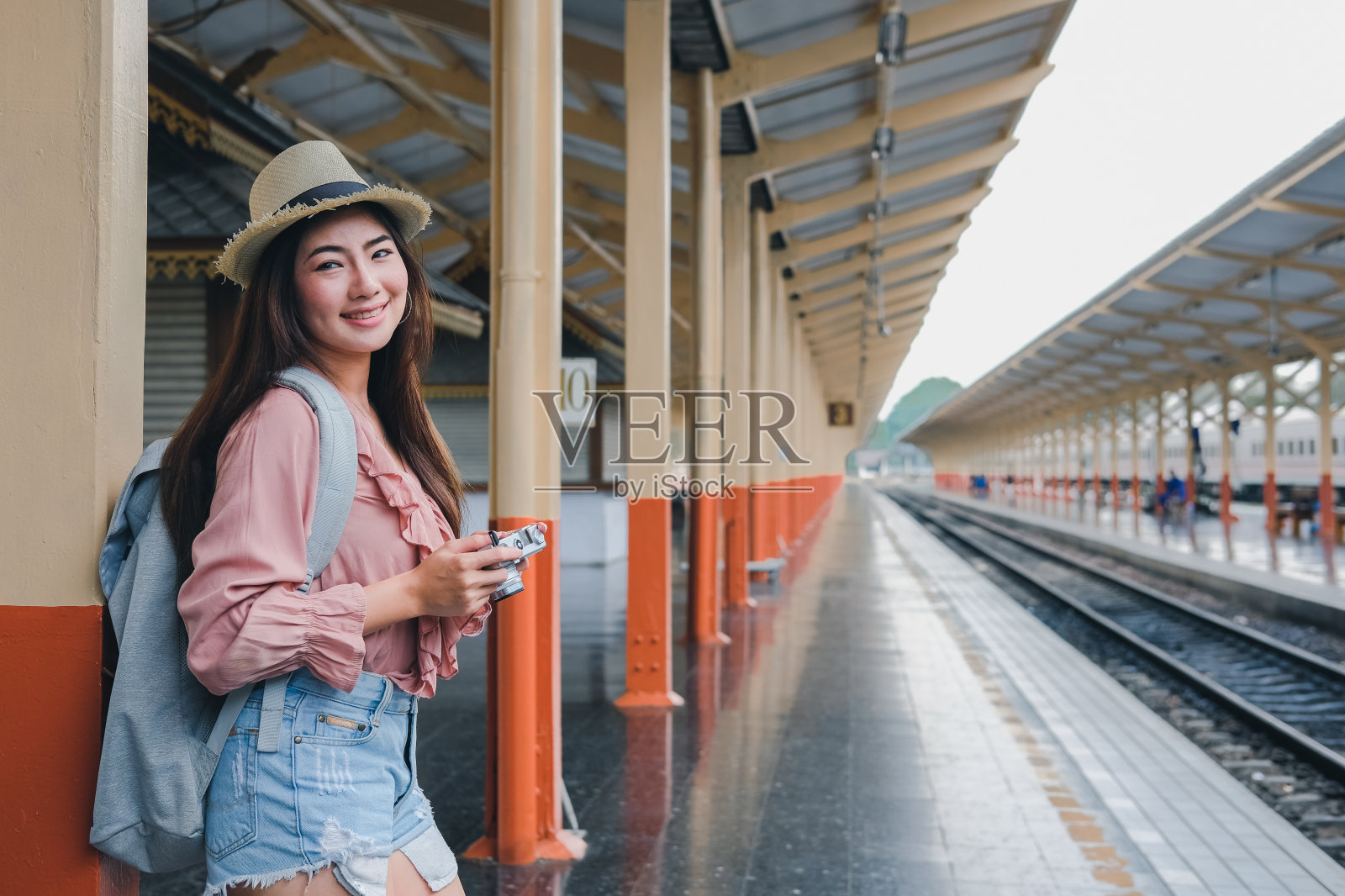 一名女子在火车站拿着相机拍照。旅行旅行旅行照片摄影图片