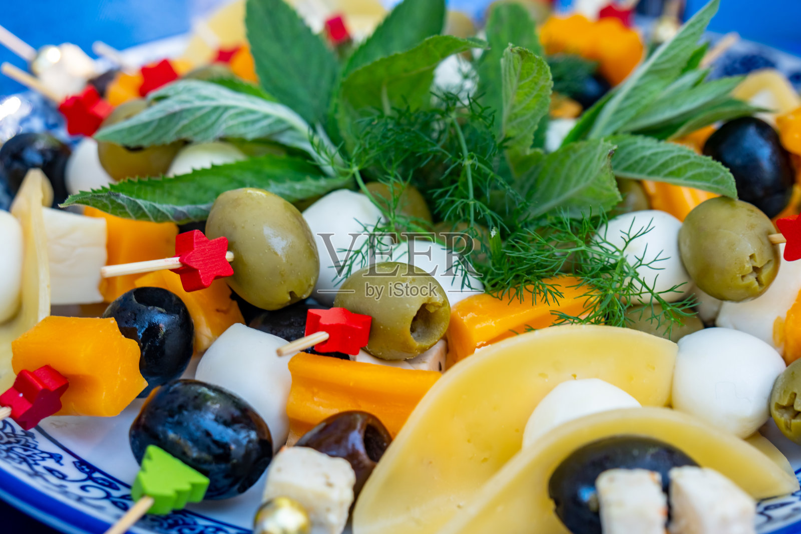 水果和蔬菜沙拉与橄榄,奶酪和其他成分。照片摄影图片