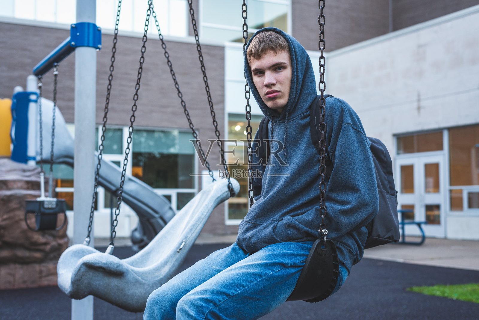 坐在秋千上的悲伤青少年照片摄影图片