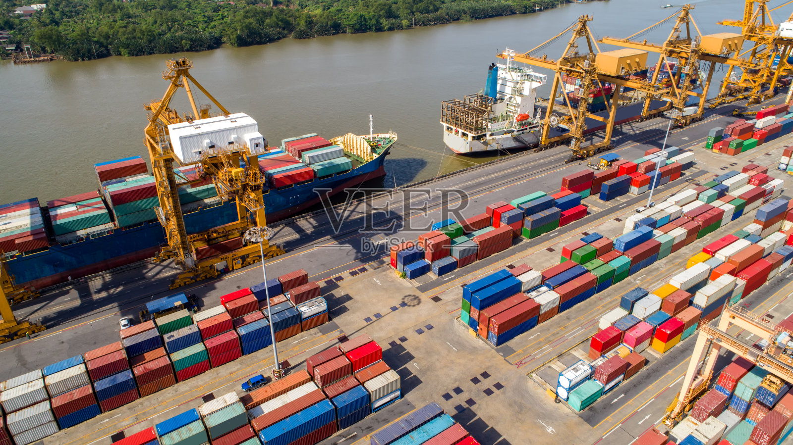 在船厂从事集装箱货轮和货机的物流运输与工作起重机桥,物流进出口和运输行业背景照片摄影图片