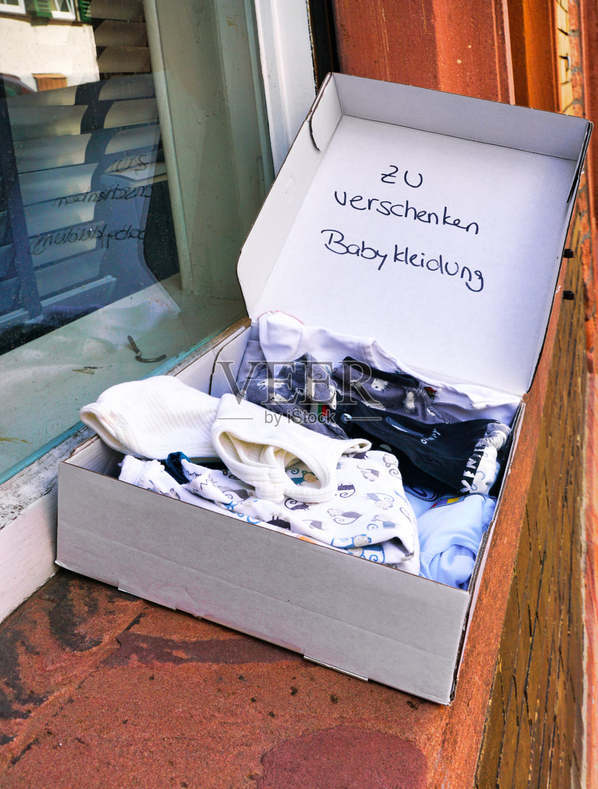 放在窗台上的盒子里的二手婴儿衣服作为礼物送给别人(zu verschenken)照片摄影图片