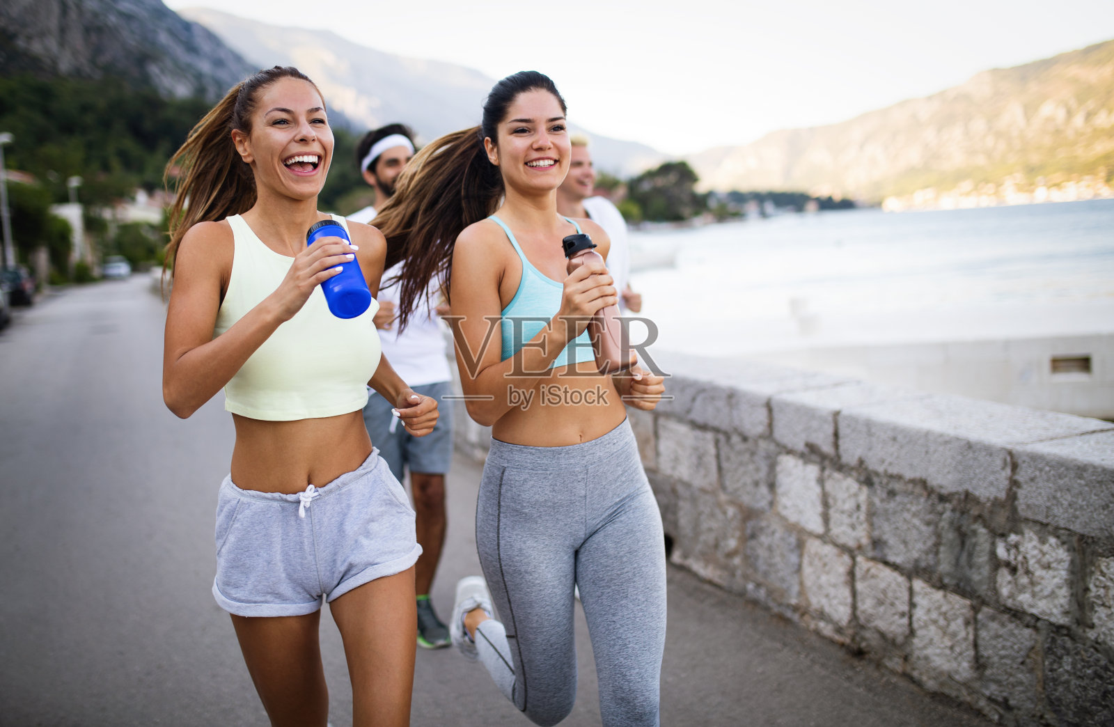 快乐健康的人们一起在夏日阳光明媚的大自然中跑步和慢跑照片摄影图片