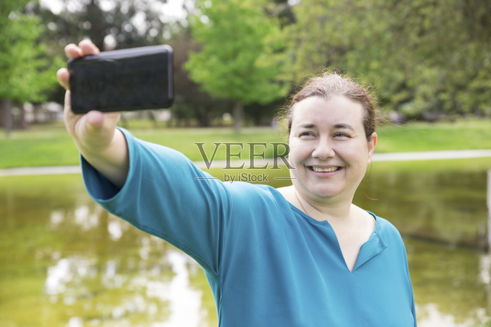 兴高采烈的胖女人在公园里自拍照片摄影图片