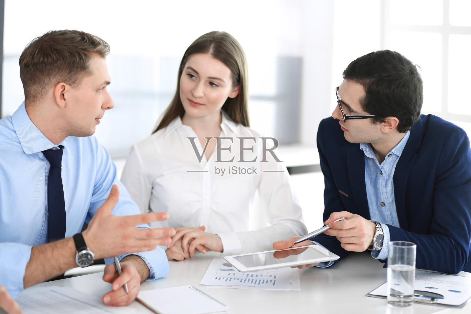 一群商务人士在现代办公室开会讨论问题。经理在谈判或头脑风暴。团队合作,伙伴关系和经营理念照片摄影图片