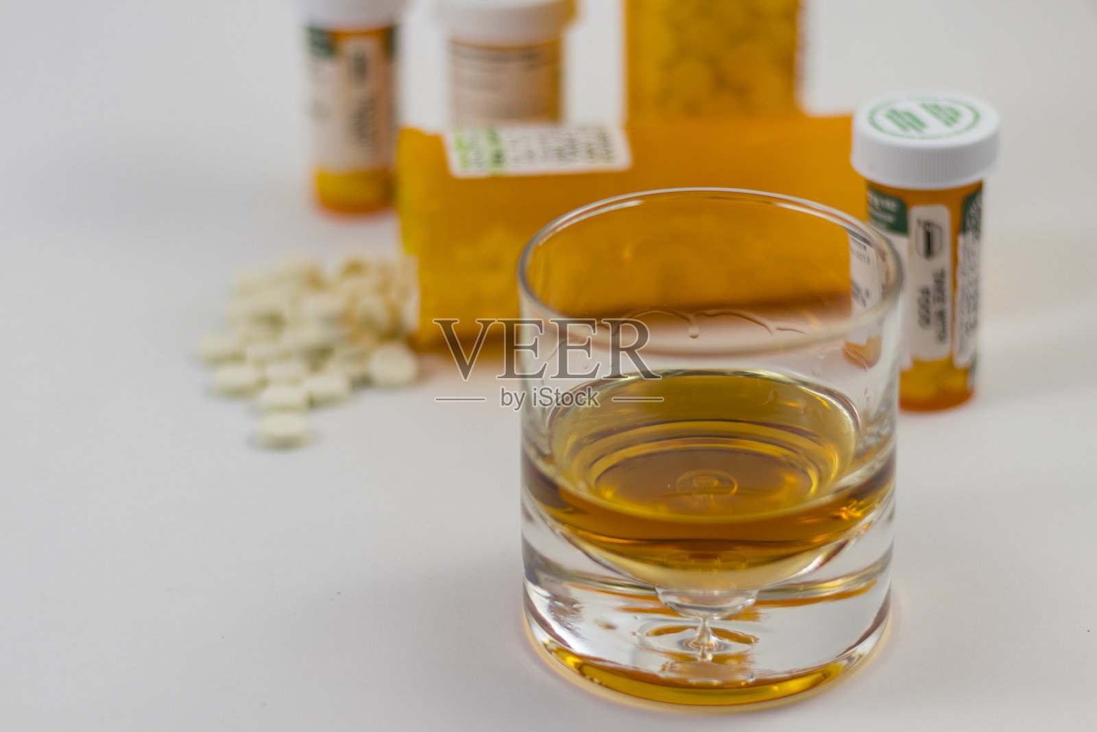 一杯酒和几瓶打翻的药丸照片摄影图片