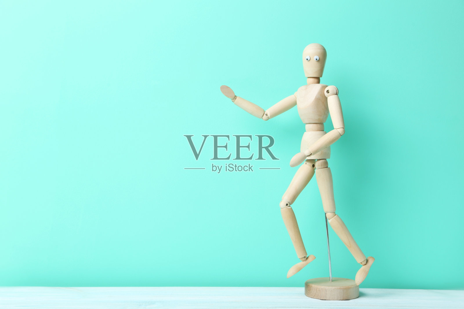 在绿色背景上有一双大眼睛的木制人物照片摄影图片