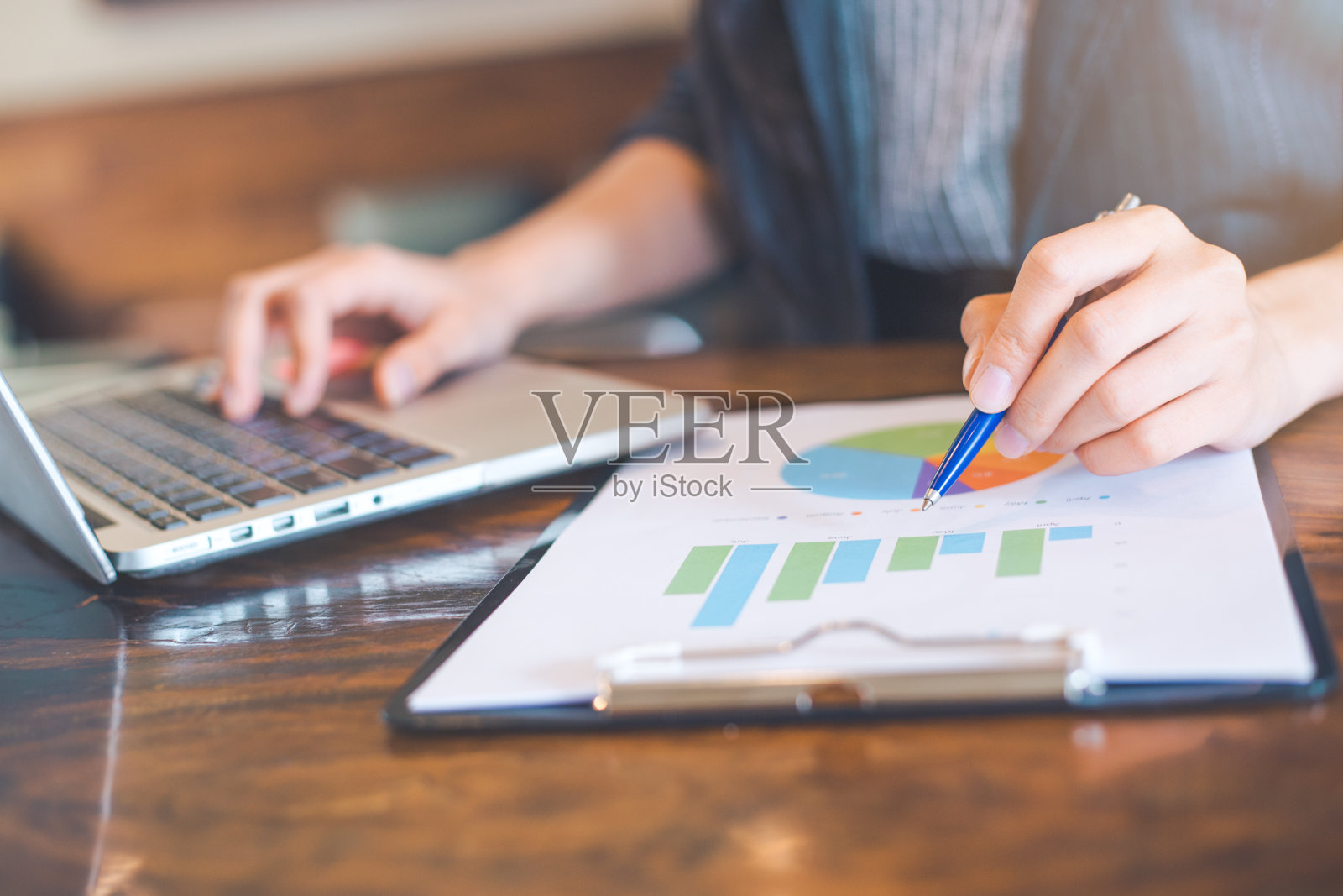 商人在分析图表和显示结果的图表。她的手握着笔,指着图表。业务分析和战略。照片摄影图片