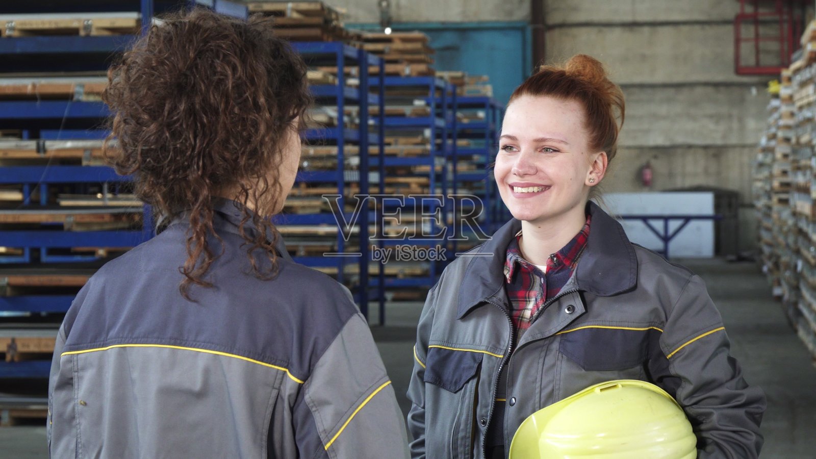 年轻漂亮的五金存储女工和她的同事聊天照片摄影图片
