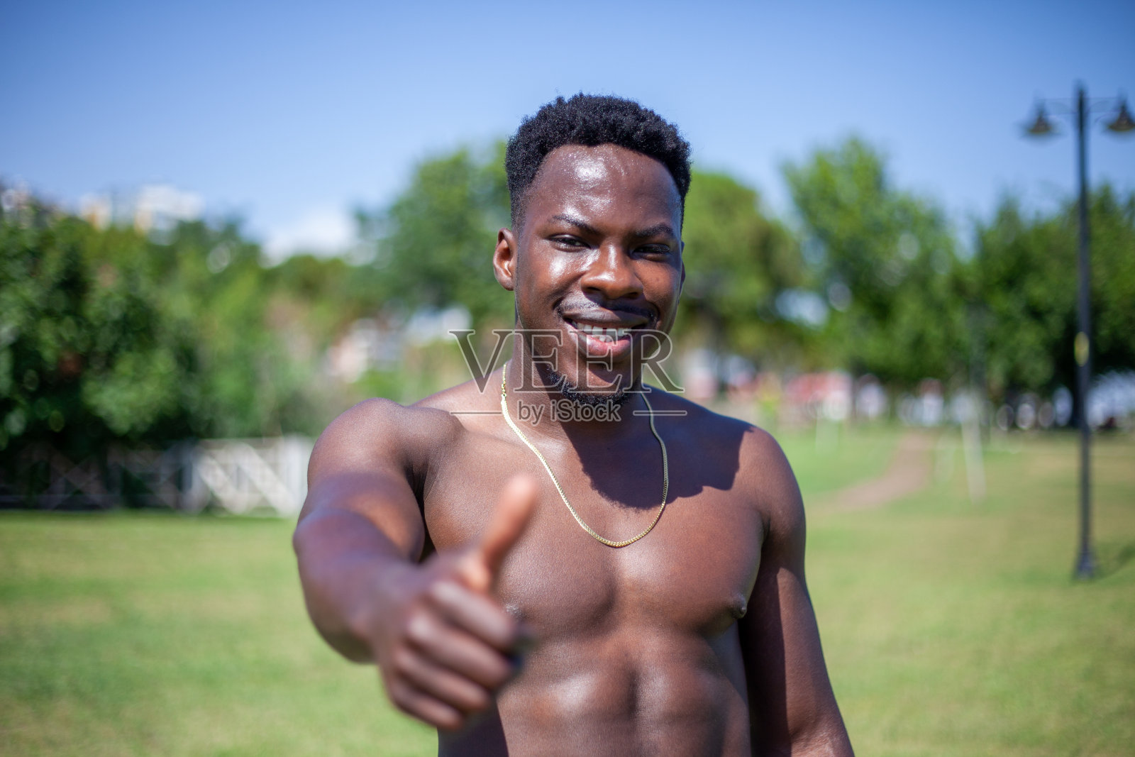 美国黑人赤膊男子展示在孤立的背景成功标志做积极的手势,拇指向上微笑和快乐。带着愉悦的表情看着镜头,胜利者的姿态。照片摄影图片