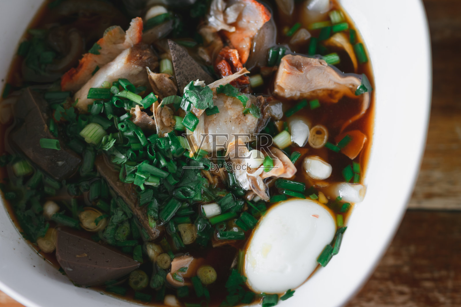 煮过猪血的泰国菜,放在木桌上,场面模糊照片摄影图片