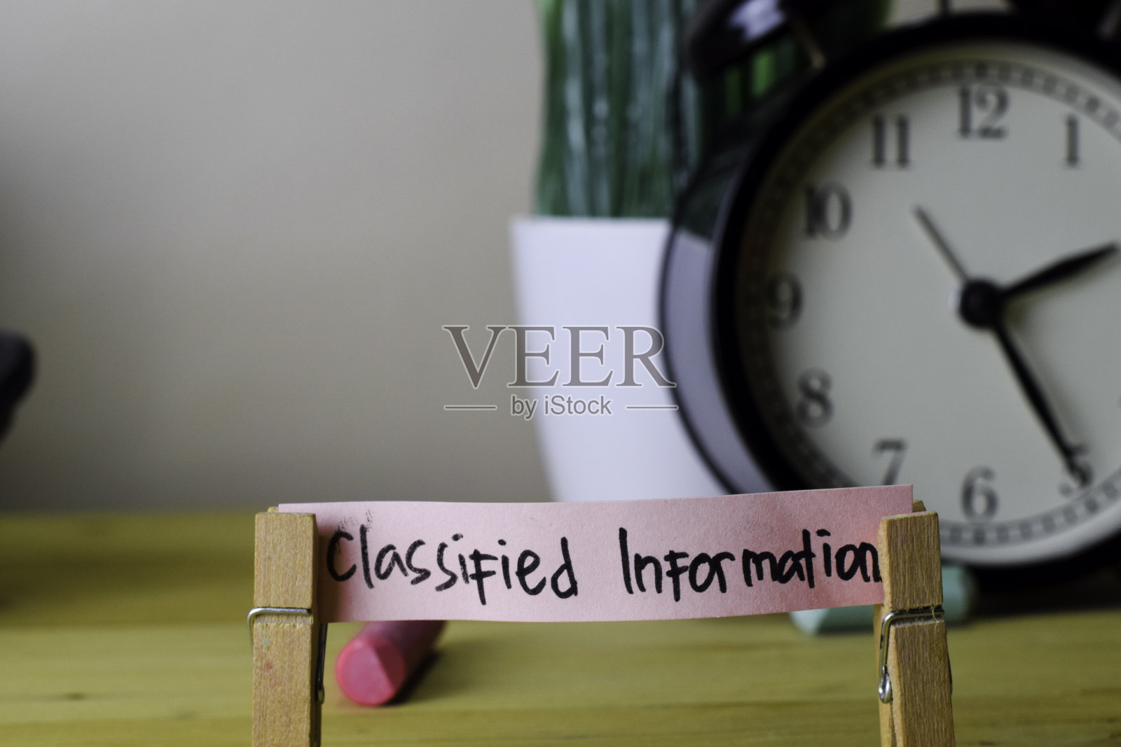 机密信息。木质办公桌上的衣服钉上的便签上的笔迹照片摄影图片