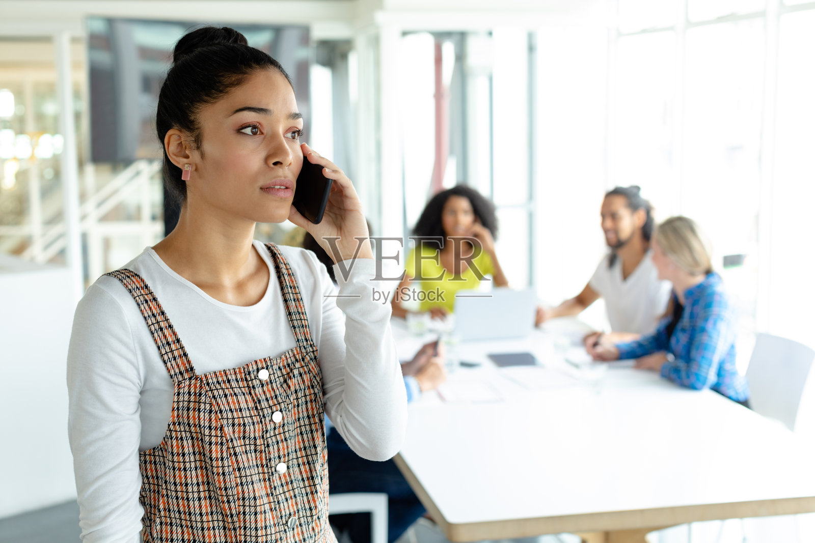 在现代办公室里打电话的女商人照片摄影图片