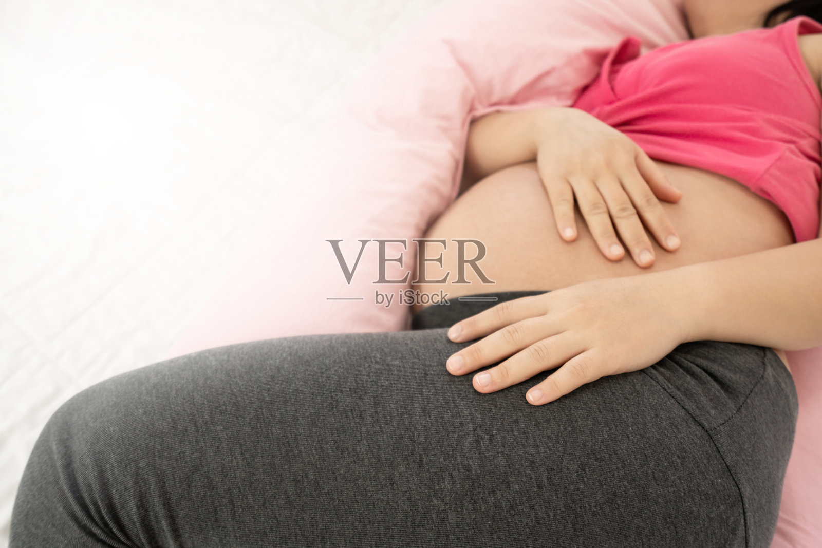 快乐的孕妇在卧室的床上睡觉照片摄影图片