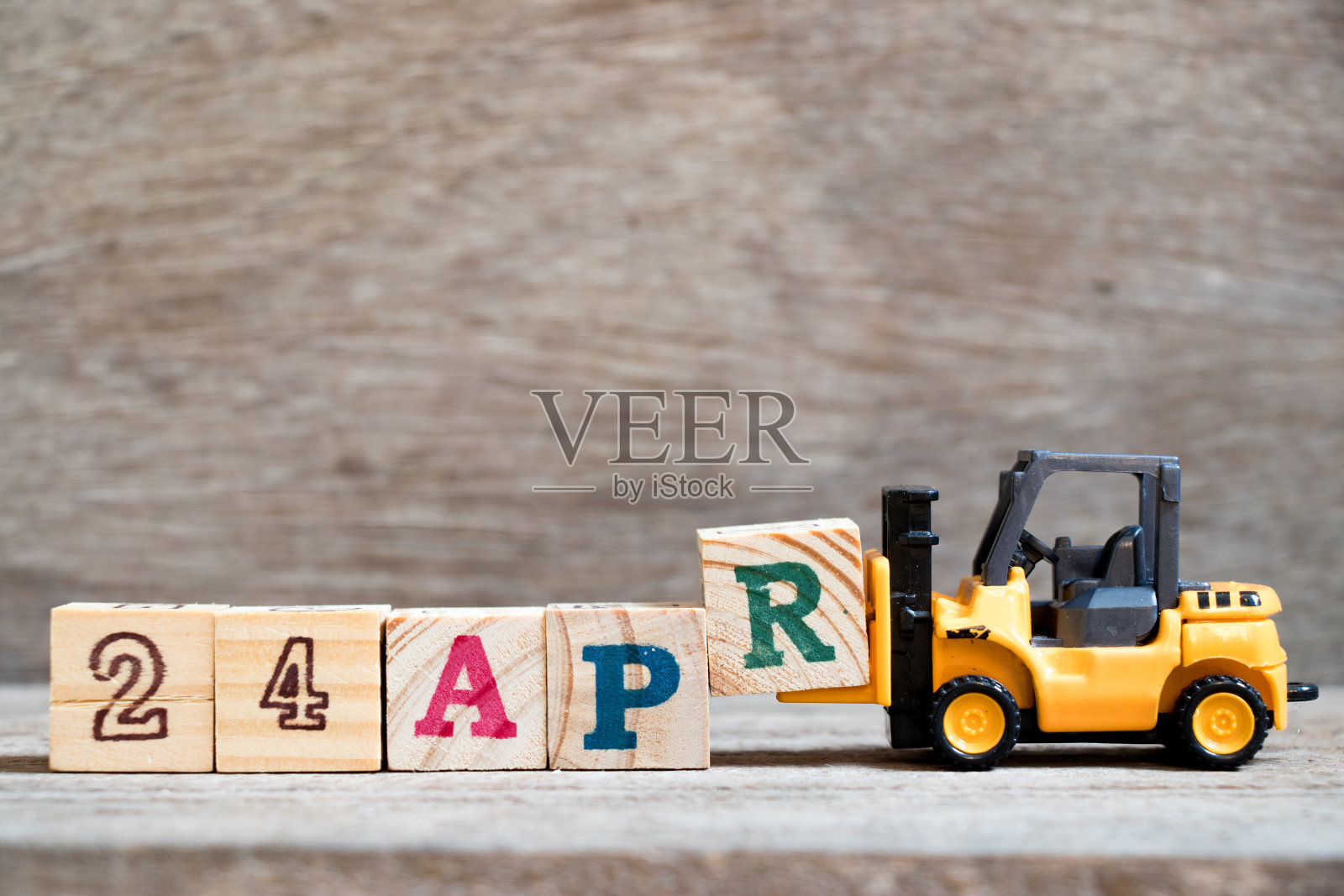 玩具叉车hold块R完成单词24apr在木材背景(概念为日历日期24月4月)照片摄影图片