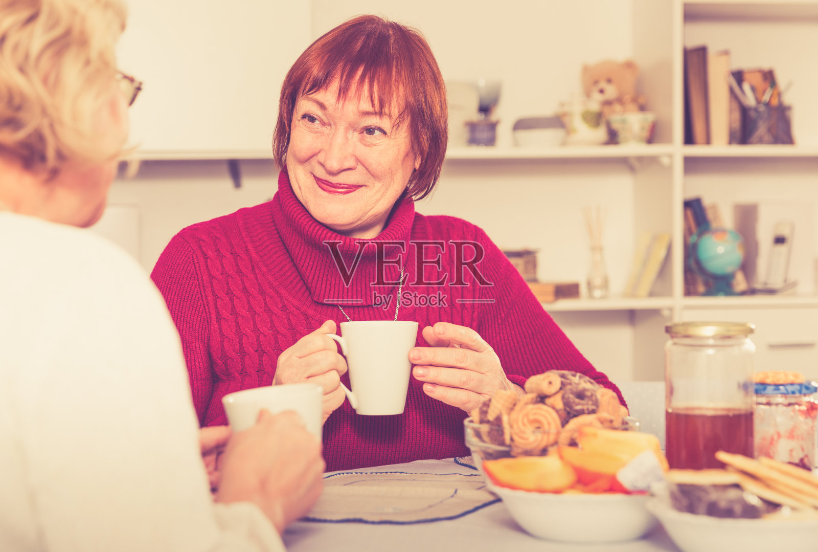 积极的老妇人在桌子上喝茶照片摄影图片
