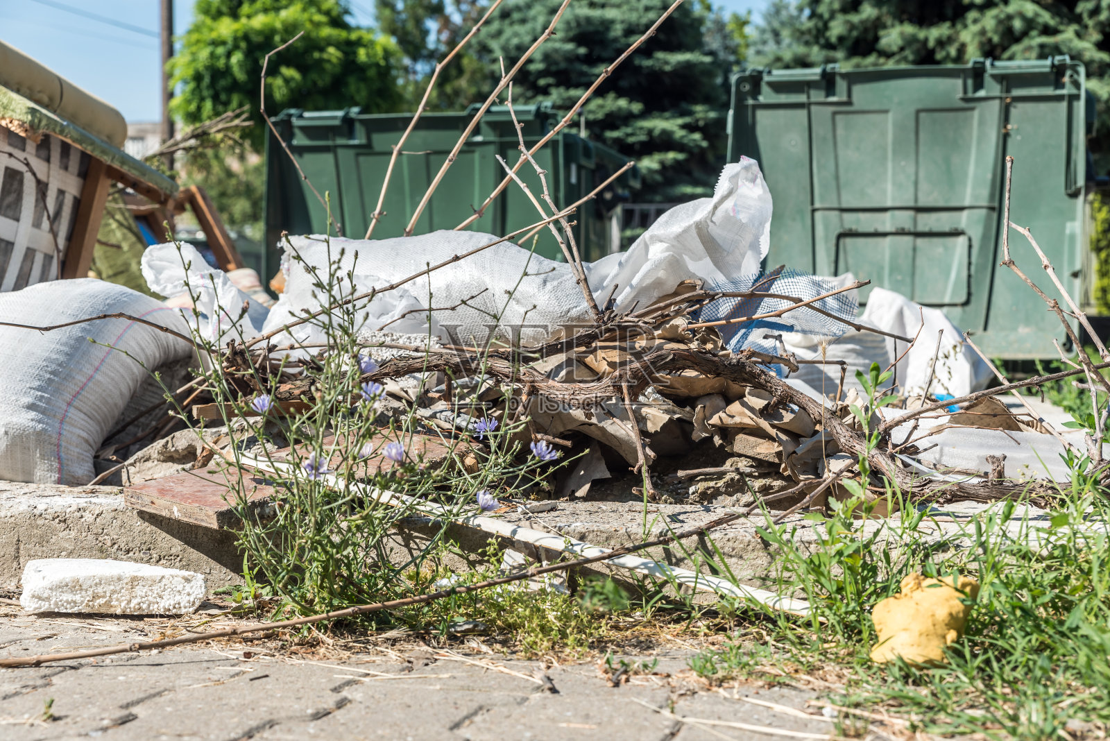 巨大的塑料垃圾桶装满了溢出的垃圾,地面和草地上的垃圾和废物污染了城市的街道照片摄影图片