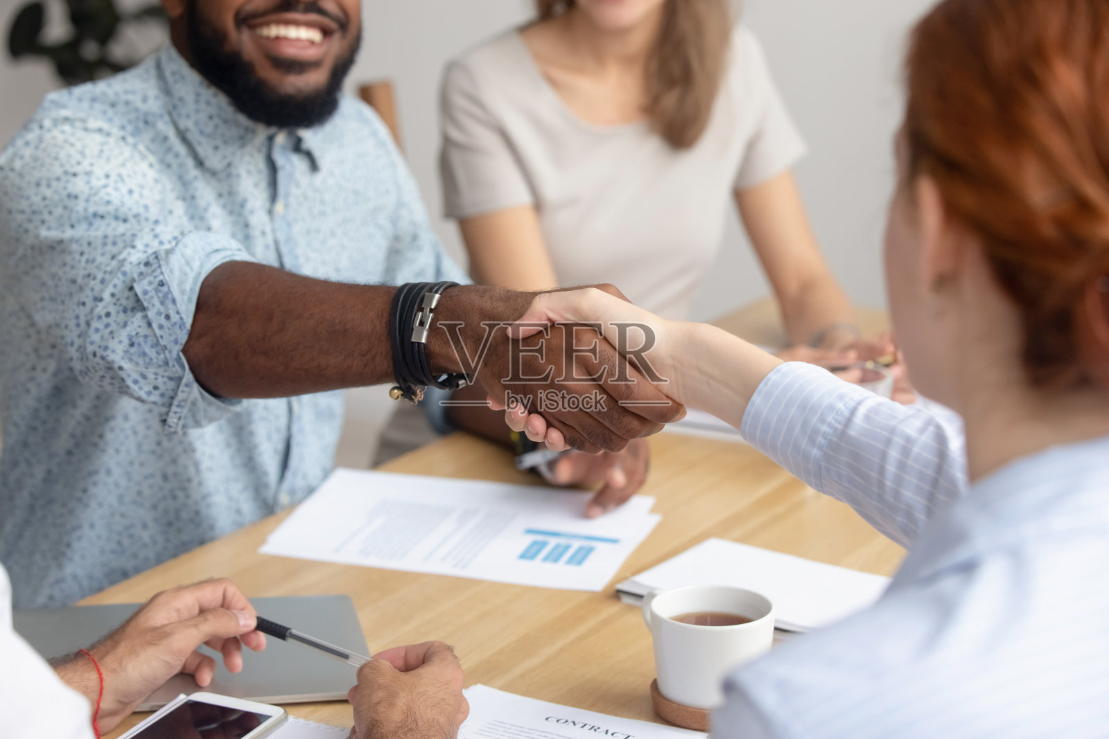 靠近男女不同的商务人士握手照片摄影图片