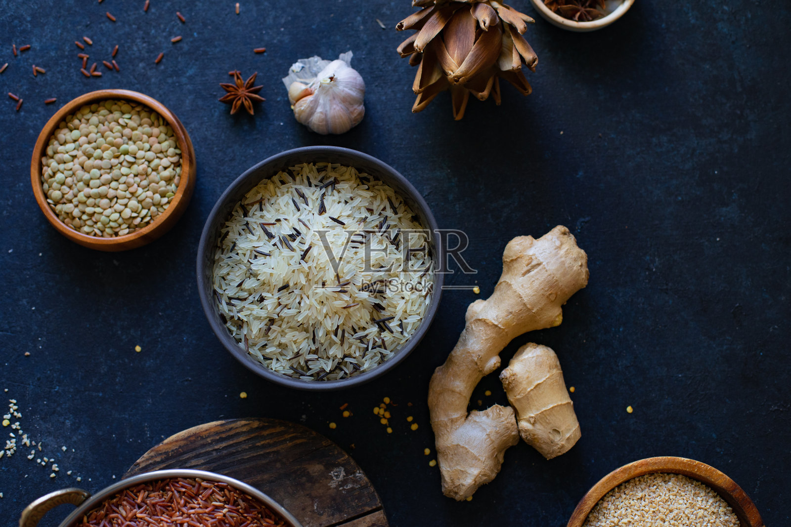 各种各样的大米和谷物与香料在蓝色的背景。糙米和混合菰米。照片摄影图片