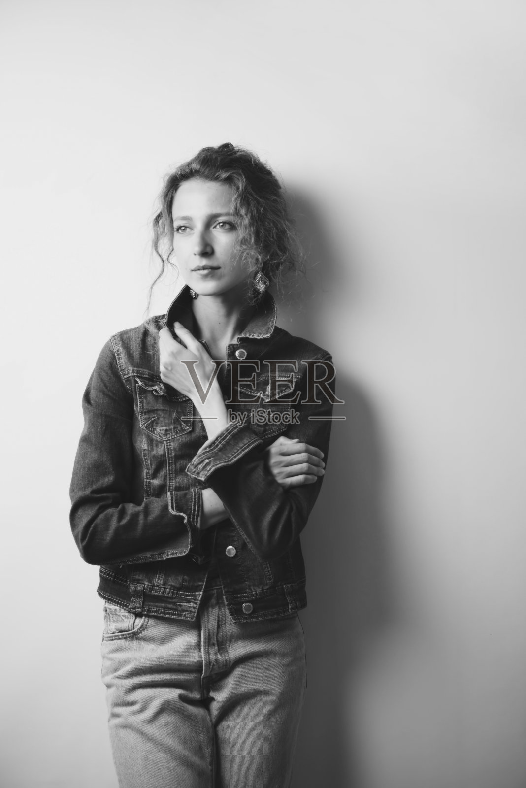 时髦的漂亮卷曲的女孩在牛仔夹克照片摄影图片
