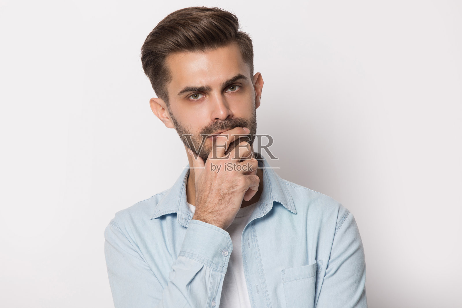 沉思的年轻人手牵着下巴感觉可疑照片摄影图片