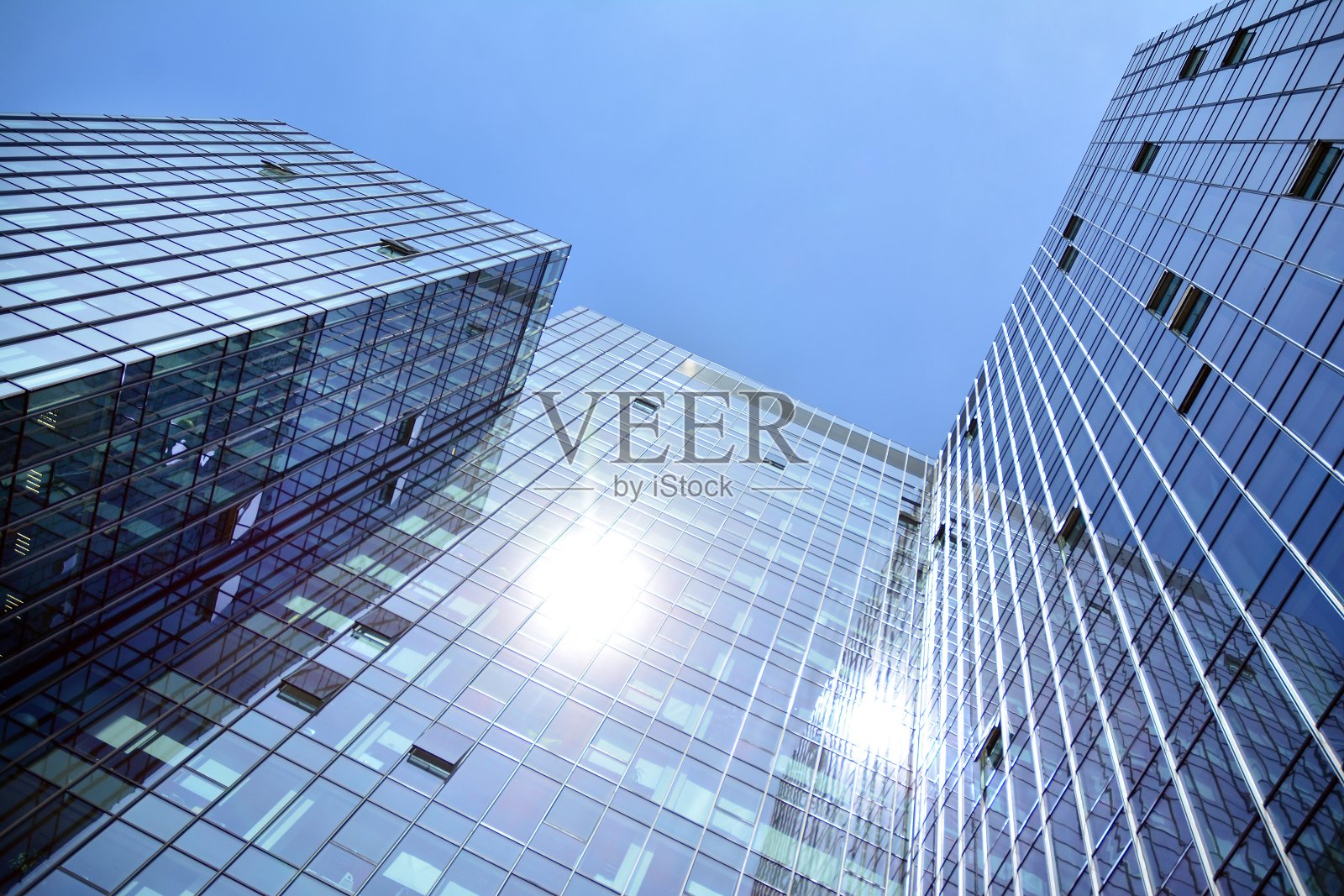 在蓝天的映衬下,现代摩天大楼的底部视图照片摄影图片