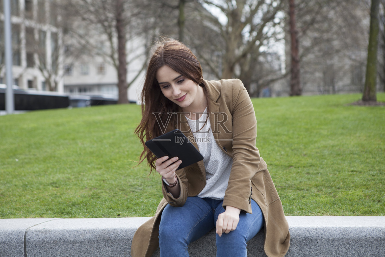 拿着电子阅读器的年轻女子照片摄影图片