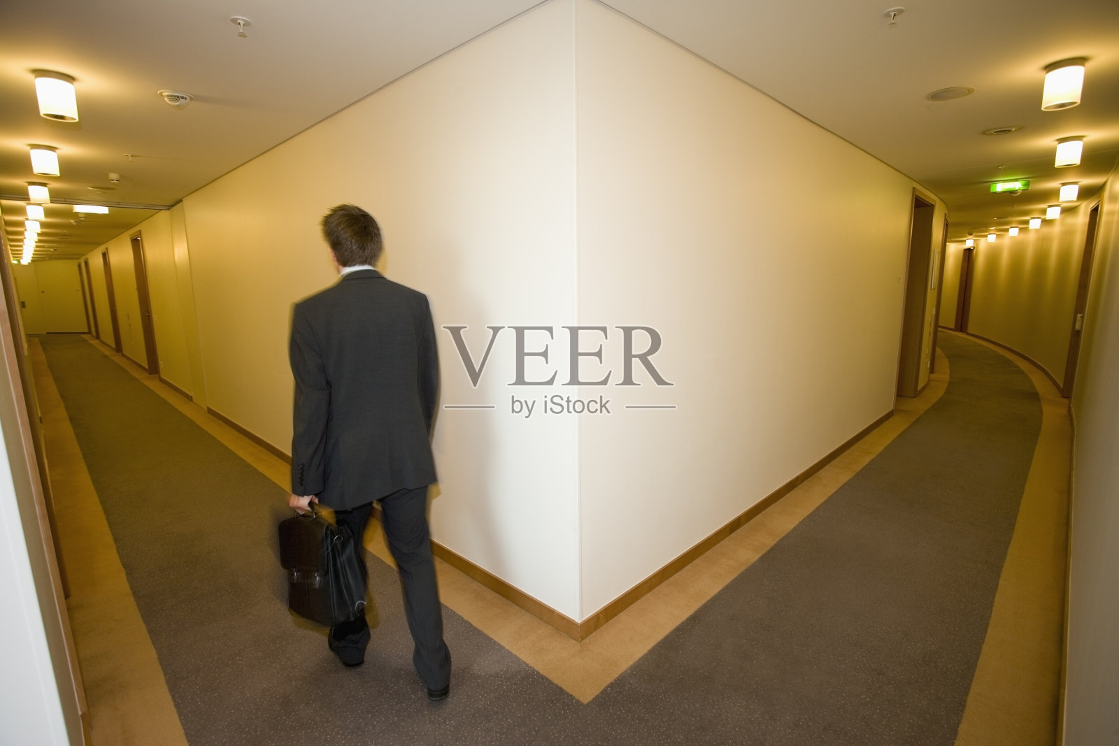 一个商人走在酒店的走廊上照片摄影图片