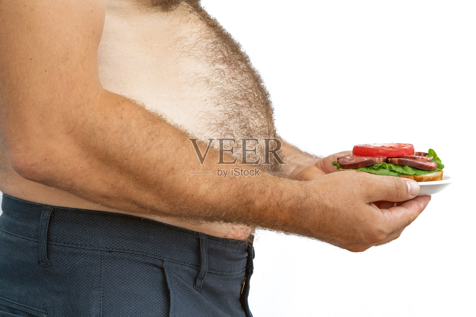 人超重。这张照片是啤酒肚、节食失败和吃错食物的象征。减肥的概念。紧的衬衫。照片摄影图片