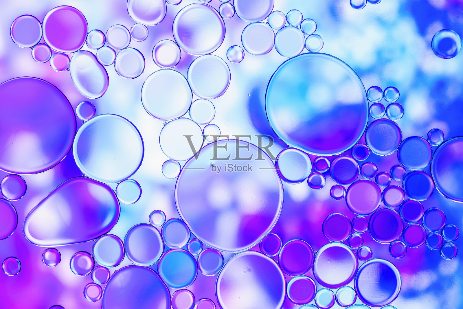 蓝色和紫色的油泡在水与抽象图案照片摄影图片